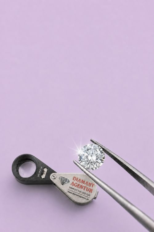 Diamant in einer Pinzette neben einer Prüflupe der Diamant Agentur
