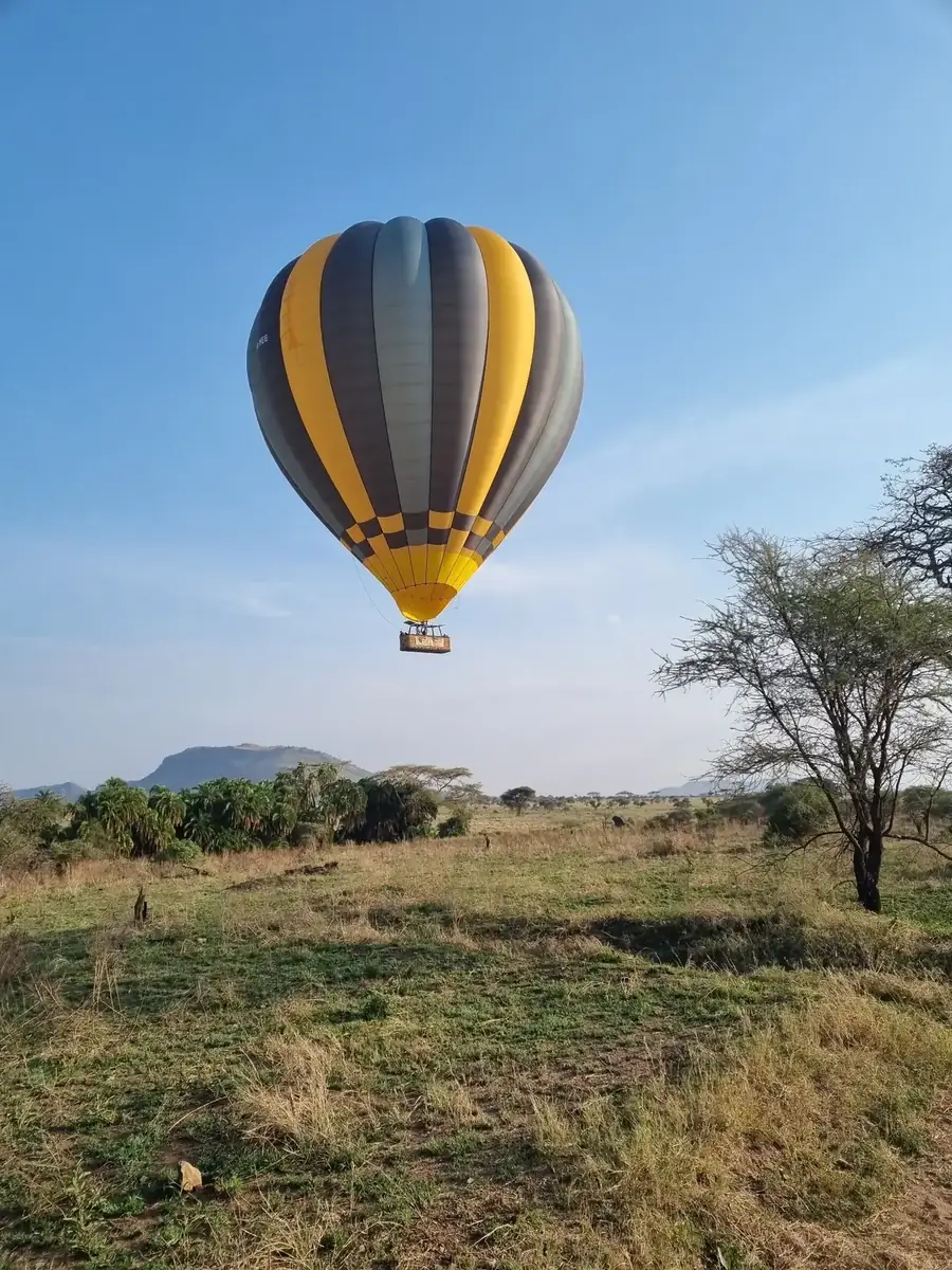 Heißluftballon über einer Landschaft in Tansania